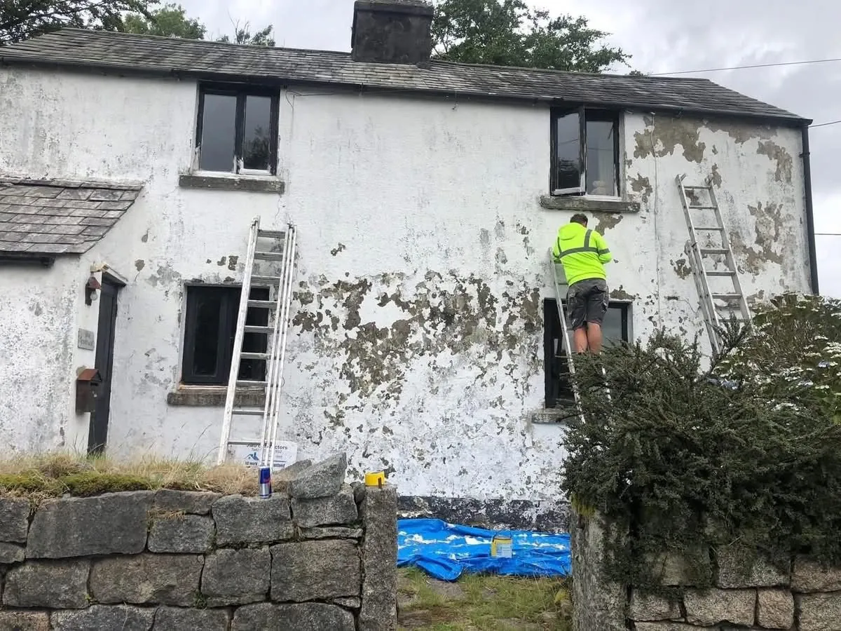 Cottage with blown, flaking render before repair in Falmouth